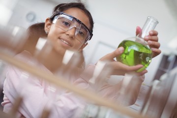 Portrait of elementary student holding green chemical in beaker