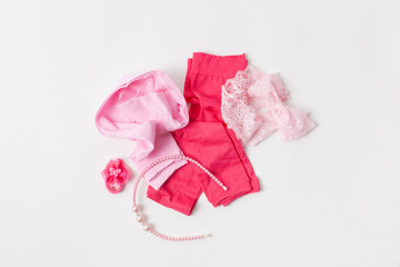A pair of pink leggings for a girl and accessories on white