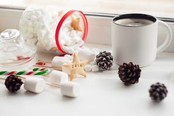 Image of Xmas sweets, traditional Christmas gingerbread with candy cane on festive table, coffee cup, nordic
