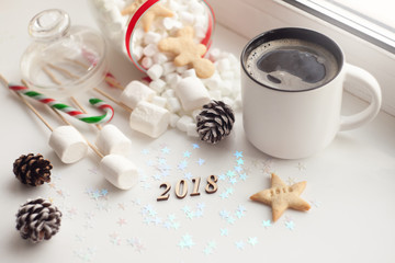Mug with hot drink and Christmas cookies star 2018. Background with cup of tea or coffee, festive decoration. Winter holiday concept. Beautiful cookies and bakery with cup of steaming beverage.