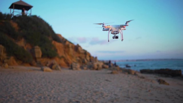 Flying drone in the beach at sunset