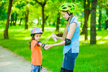 Mother spraying insect repellents on skin girl