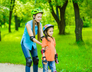 Mother teaches her daughter to ride roller skates