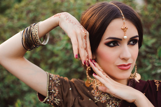 Mehendi on the hands of girls, Woman Hands with brown mehndi tattoo. Hands of Indian bride girl with brown henna tattoos.