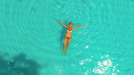 Woman relaxing in swimming pool.