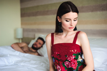 Fototapeta premium Couple in bed, portrait of a sad woman in bed with her husband