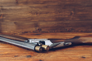 Open hunting rifle isolated on wooden background