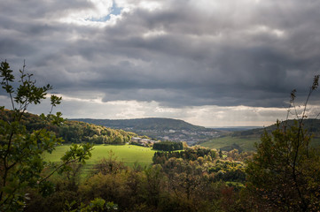 Vereinzelte Sonnenstrahlen durchbrechen die Wolken und erleuchten die Landschaft