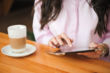 Close up hand woman using tablet in coffee shop