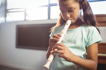 Girl practicing flute in class - Powered by Adobe