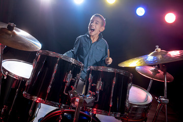 Fototapeta na wymiar young boy playing drums