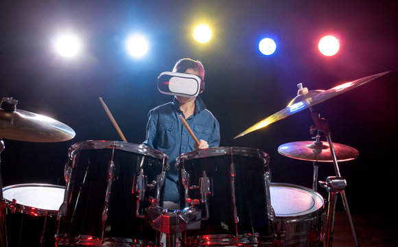 The boy learns to play drums, with glasses for virtual reality