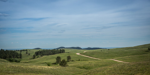 Fototapeta na wymiar A distant road across a prairie with approaching storms in South Dakota, USA