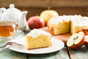 Autumn dessert. Homemade apple cake with whipped cream served with black tea and raw apples on robin egg blue table