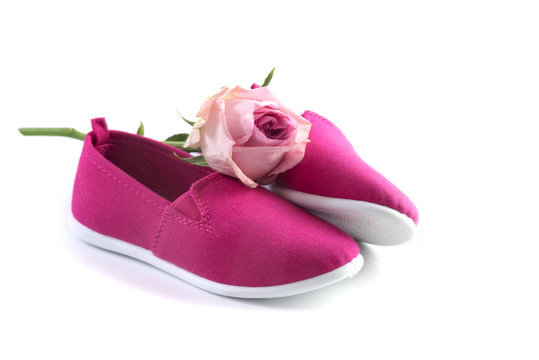 pink kid shoes and a rose isolated on a white background, concept International Day of the Girl Child on 11 October, copy space