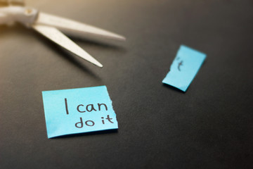 Motivational quote on sticky paper with scissors on dark background. No execuses, i can do it.