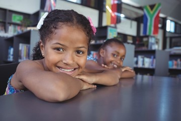 Portrait of smiling girls leaning on desk