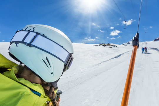 Happy young woman skier on ski drag lift.