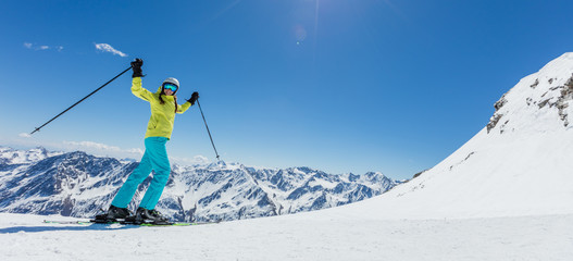 Happy young woman skier enjoying sunny weather in Alps - obrazy, fototapety, plakaty