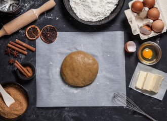Bakery ingredients, eggs, flour, butter and other. Raw dough with oil on kitchen table flat lay. Bakery, recipe, home cooking concept. Raw dough on parchment paper.