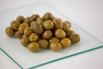 Close up of green olives on glass