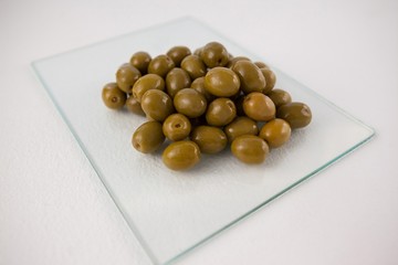 Close up of green olives on glass slab