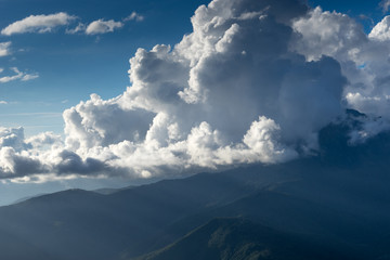 mountain landscape on the background of the cloudy sky and sun rays