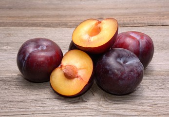 Fototapeta na wymiar Group of fresh plums on wood table