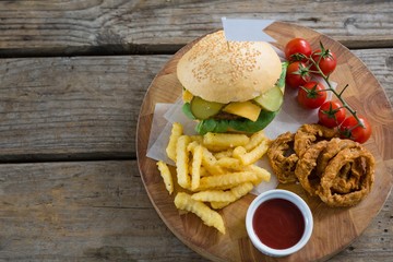 Overhead view of burger and fries with onion rings by sauce