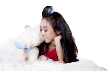 Young woman kissing her Maltese dog