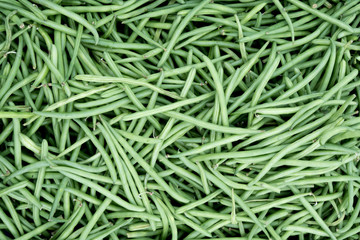 Bushel of green beans at an outdoor market in Antwerp Belgium. Pile of green beans at a farmers market. Close up of green beans with soft natural light.