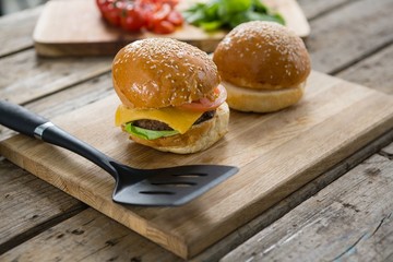 Close up of burgers and vegetables on cutting board