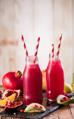 Pomegranate drink on a wooden background. Selective focus.