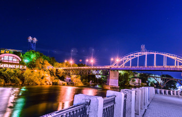 Beautiful Night view of an Artificial Waterfall and footbridge on Monastyrsky Island in the city of Dnepr on the river.. Dnepropetrovsk, Dnipropetrovsk, Dnipro city, Ukraine