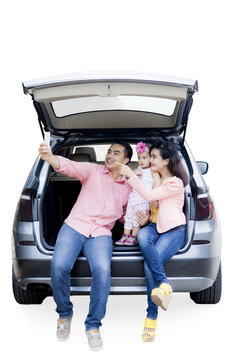 Asian family with smartphone on the car