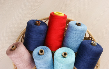 bobbin with thread in a basket on the table