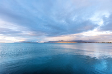 Obraz premium Embankment of Reykjavik with mountains and blue ocean.