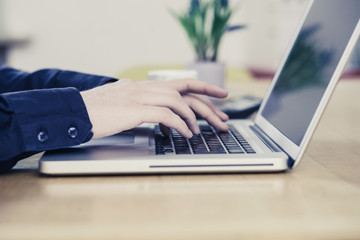 Young man typing on notebook at desk