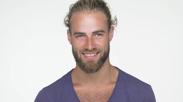 closeup caucasian handsome man wearing blue t-shirt looking at camera smiling broadly with white teeth nodding positively over white background. Concept of emotions