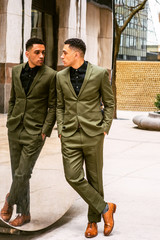 Fototapeta premium American Businessman looking at mirror, wearing green suit, black undershirt, brown leather shoes, standing against mirror, looking at reflection. Concept of self assured, self esteem, self checking..