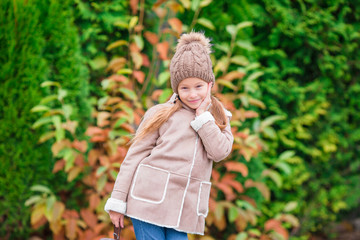 Portrait of adorable little girl outdoors at beautiful autumn day