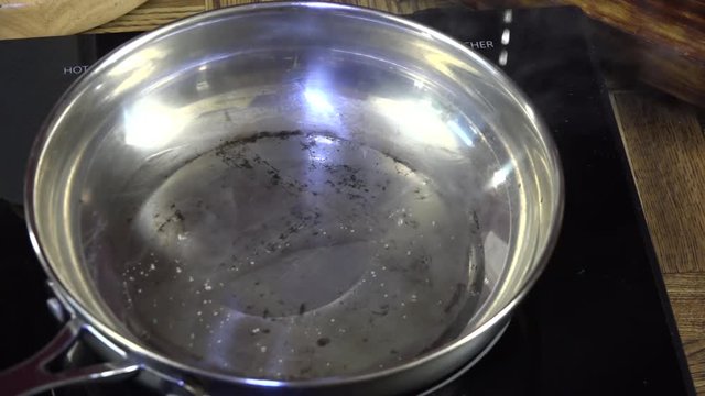 Overhead view of hot oil smoking in a frying pan