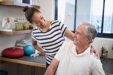 Smiling female doctor looking at senior patient