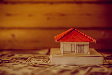 House from the paper and money on wooden background