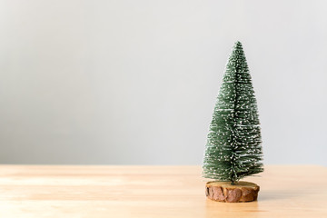 Christmas tree on wood table with white wall background, Christmas holiday celebration concept, Copy space