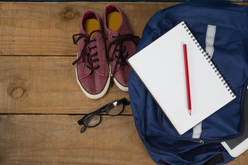 Shoes, spectacles, book, pencil, digital tablet and schoolbag on