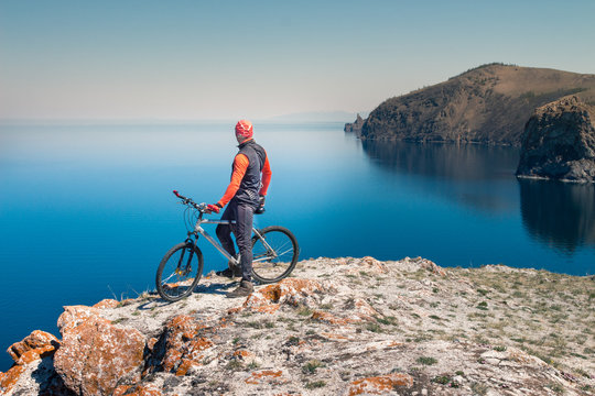 A man on a bicycle by the sea