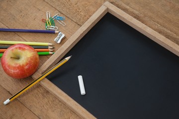 School supplies and apple on wooden table