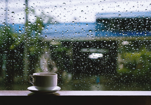 Fototapeta Cup of Hot Drinks on wooden table in rainy day