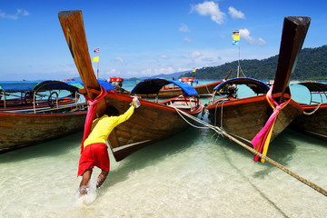 long tail boat, in white sand beach in  andaman sea